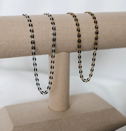 A variety of delicate metal chains for permanent jewelry appointments, showcased on a professional display.